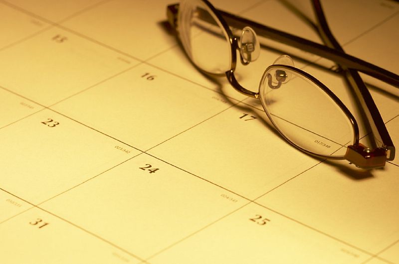Calendar with glasses resting in yellow light